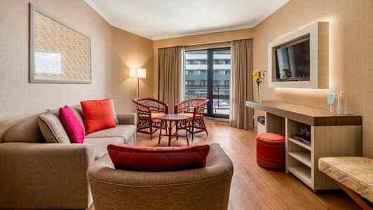 Moderni hotellihuone, jossa istuinryhmä ja sisustus. (Tekoälyn luoma teksti)