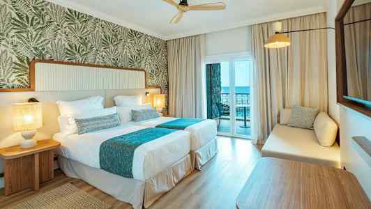 Hotellihuone, jossa kaksi erillistä vuodetta ja parveke merinäköalalla. (Tekoälyn luoma teksti)