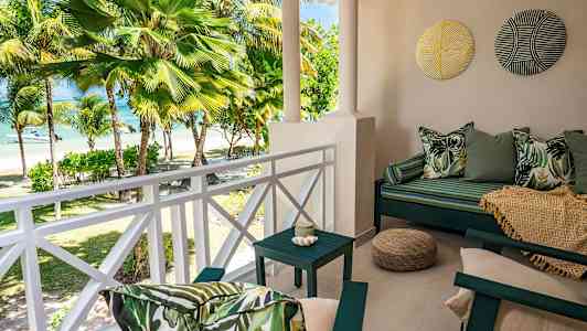 Terassi, josta on näkymä palmupuihin ja rannalle. (Tekoälyn luoma teksti)