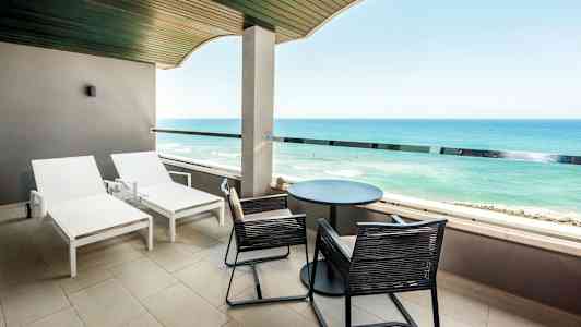 Parveke aurinkotuoleilla ja näkymä merelle. (Tekoälyn luoma teksti)