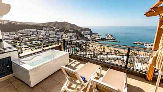 Parveke kahdella aurinkotuolilla ja porealtaalla, näkymä merelle ja ympäristöön. (Tekoälyn luoma teksti)