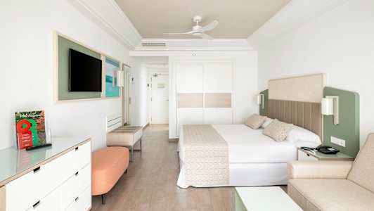 Moderni hotellihuone, jossa on suuri sänky ja tyylikäs sisustus. (Tekoälyn luoma teksti)