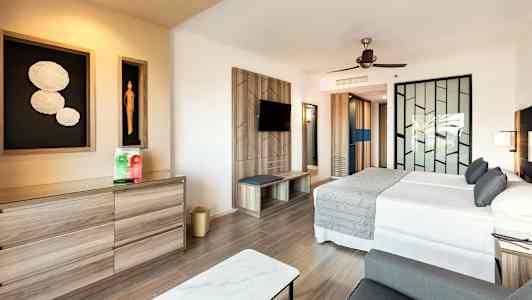 Moderni hotellihuone, jossa on parivuode, koristeellinen seinä ja lipasto. (Tekoälyn luoma teksti)