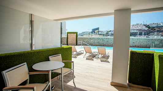 Ulkoiluterassi istuinkalusteilla ja näkymä uima-altaalle. (Tekoälyn luoma teksti)