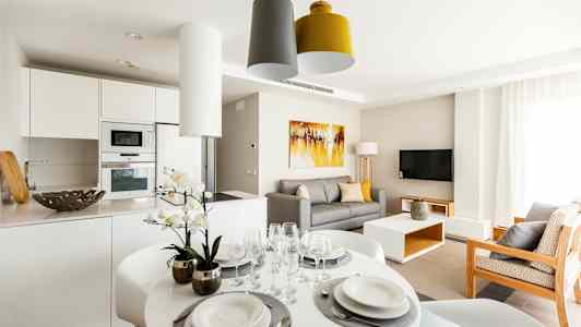 Moderni olohuone keittiöosuudella, ruokapöydällä ja sohvalla. (Tekoälyn luoma teksti)