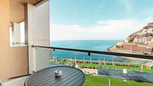 Näkymä parvekkeelta merelle ja vehreään hotellipuutarhaan. (Tekoälyn luoma teksti)