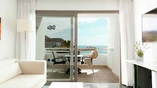 Moderni ja valoisa olohuone, josta on näkymä parvekkeelle, joka tarjoaa merimaisemaa. (Tekoälyn luoma teksti)