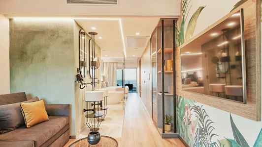 Tyylikkään hotellihuoneen sisustus, jossa sohva, peilit ja TV seinällä. (Tekoälyn luoma teksti)