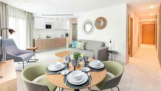 Modernisti sisustettu olohuone, jossa keittiö ja ruokapöytä. (Tekoälyn luoma teksti)