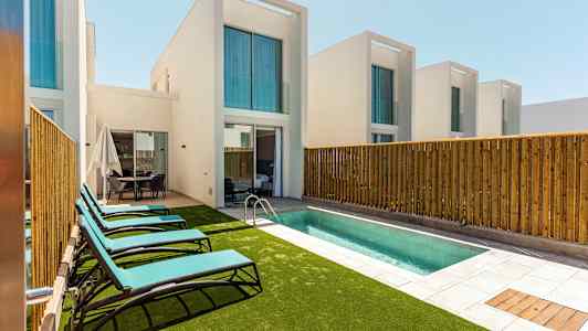 Yksityiset huvilat altaan ja aurinkotuolien kanssa. (Tekoälyn luoma teksti)