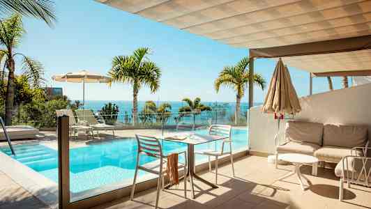 Terassi uima-altaalla ja merinäköalalla, ympärillä palmuja. (Tekoälyn luoma teksti)