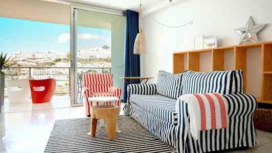 Olohuone, jossa sohva ryhmä lasioven edessä, joka johtaa parvekkeelle. (Tekoälyn luoma teksti)