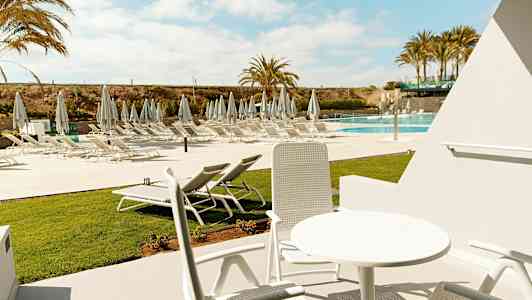 Ulkokalusteet aurinkoisen ympäristön keskellä, näkymät uima-altaan aurinkotuoleihin. (Tekoälyn luoma teksti)