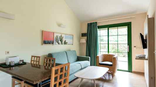 Huone, jossa istumakalusteita ja ruokapöytä, kuvattu vihreän oven ja sisustuksen kanssa. (Tekoälyn luoma teksti)