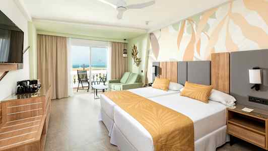 Hotellihuone, jossa kaksi yhden hengen sänkyä ja parveke merinäköalalla. (Tekoälyn luoma teksti)