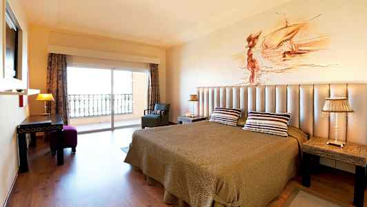 Huoneessa on parivuode, kattolamppu ja parvekenäkymä. (Tekoälyn luoma teksti)