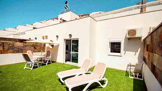 Yksityinen terassi aurinkotuoleilla ja ulkokalusteilla. (Tekoälyn luoma teksti)