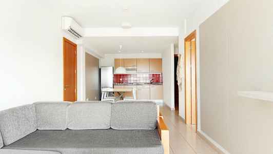 Kuva vaaleasta olohuoneesta, jossa on harmaa sohva etualalla ja keittiö taustalla. (Tekoälyn luoma teksti)