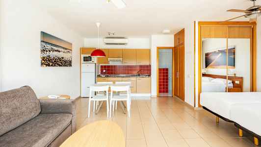 Nykyaikainen hotellihuone avoimella keittiöllä ja makuutilalla. (Tekoälyn luoma teksti)