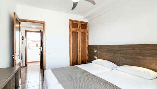 Kahden hengen huone, jossa kaksi vuodepaikkaa, parvekkeen ovi ja vaatekaappi. (Tekoälyn luoma teksti)