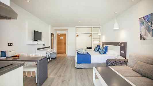 Hotellihuone, jossa on sänky, sohva ja televisio. (Tekoälyn luoma teksti)