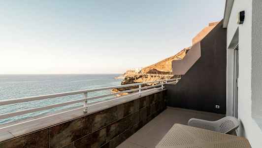 Parveke, jolta näkymät merelle ja kallioille. (Tekoälyn luoma teksti)