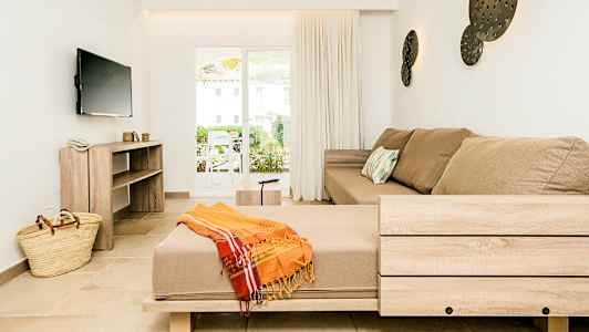 Sisustus vaaleassa olohuoneessa, jossa beige sohva ja leveä ikkunallinen ovi. (Tekoälyn luoma teksti)