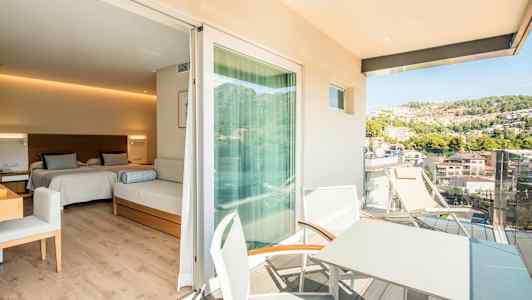 Hotellihuone, jossa on kaksi vuodetta ja istuinhuonekalu, siihen liittyvä parveke, jossa on pöytä ja tuolit sekä näkymä vehreälle kukkulalle. (Tekoälyn luoma teksti)