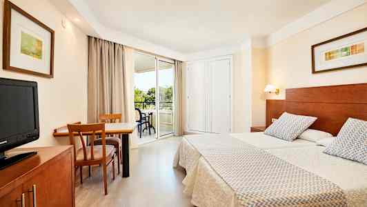 Kuva hotellihuoneesta, jossa on kaksi yhden hengen vuodetta, työpöytä tuoleineen ja parveke. (Tekoälyn luoma teksti)