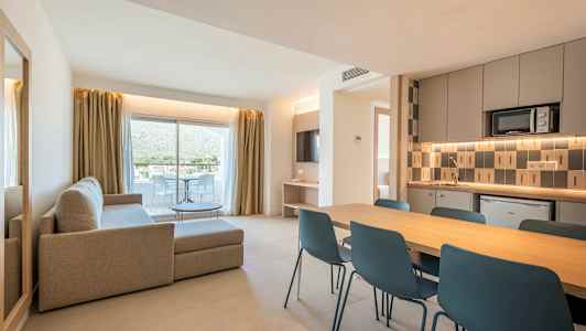 Moderni asunto, jossa olohuone, ruokailutila ja keittiö. Suuret lasiovet johtavat parvekkeelle. (Tekoälyn luoma teksti)