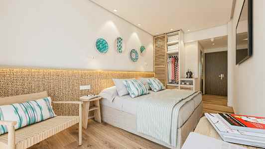 Hotellihuone, jossa parisänky, istumapaikka ja avoin vaatetila. (Tekoälyn luoma teksti)