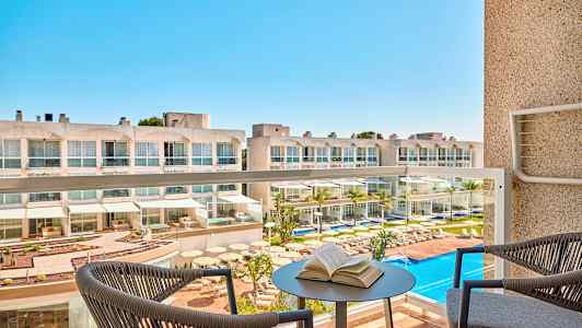 Hotelli, jossa on uima-allasalue, nähtynä parvekkeelta. (Tekoälyn luoma teksti)