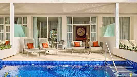 Terassi, jossa aurinkotuoleja ja istuimia yksityisen altaan edessä. (Tekoälyn luoma teksti)