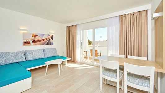 Vaalea huone, jossa sininen sohva, pöytä tuoleineen ja lasiovi parvekkeelle. (Tekoälyn luoma teksti)