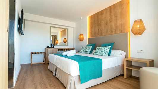 Hotellihuone, jossa on parisänky, turkooseja yksityiskohtia ja puusisustus. (Tekoälyn luoma teksti)