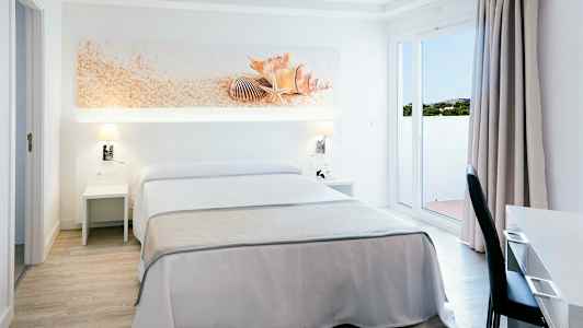 Hotellihuone, jossa on parivuode, valkoinen ja beige sisustus, koristeena simpukoita sängyn yläpuolella. (Tekoälyn luoma teksti)