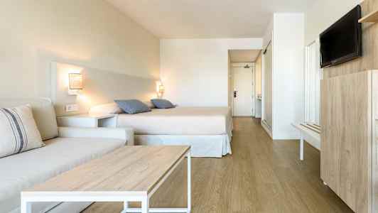 Hotellihuone, jossa sänky, sohva ja televisio. (Tekoälyn luoma teksti)