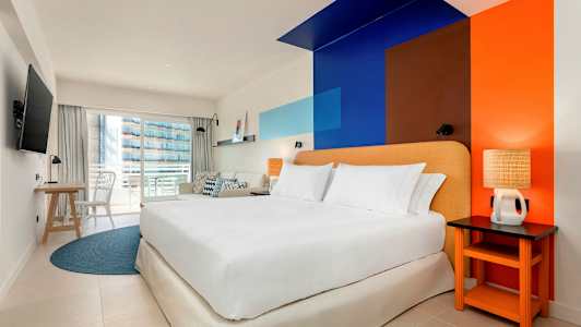 Hotellihuone, jossa on parivuode, värikäs seinädesign ja parveke. (Tekoälyn luoma teksti)