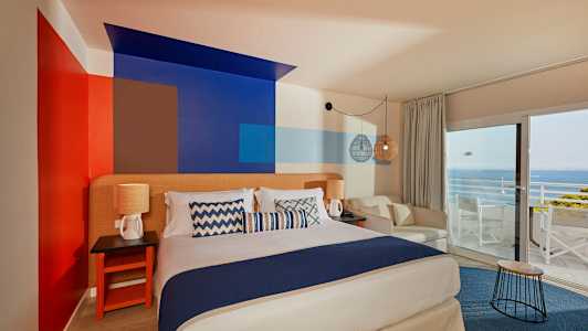 Huone, jossa on parivuode, koristeellisesti maalatut seinät, istuinpaikat ja näkymä merelle suurten ikkunoiden kautta. (Tekoälyn luoma teksti)