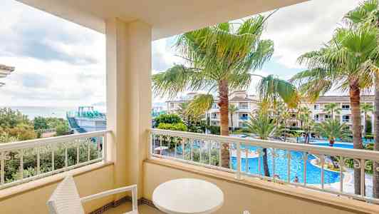 Parveke, jolta on näköala uima-allasalueelle ja palmuihin. (Tekoälyn luoma teksti)