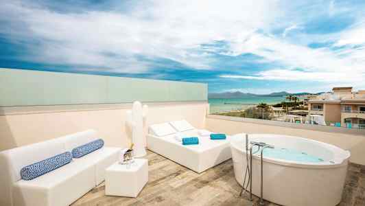 Katolla oleva terassi merinäköalalla, varustettuna porealtaalla, aurinkotuoleilla ja sohvaryhmällä. (Tekoälyn luoma teksti)