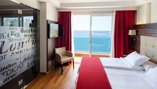 Hotellihuone, jossa on suuret vuoteet, punainen sisustus ja parveke, josta on näkymä merelle. (Tekoälyn luoma teksti)