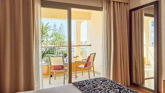 Hotellihuone, jossa parveke ja näkymä vihreään maisemaan. (Tekoälyn luoma teksti)