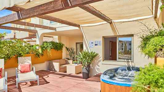 Terassi, jossa ulkokalusteita, kasveja ja poreallas. (Tekoälyn luoma teksti)