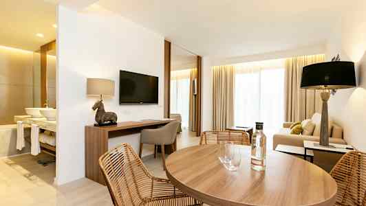 Huone, jossa ruokapöytä, sohvakulmaus ja kirjoituspöytä. (Tekoälyn luoma teksti)