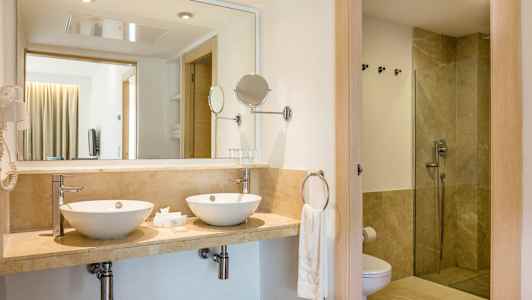 Kylpyhuone, jossa kaksi pesuallasta ja suihku. (Tekoälyn luoma teksti)