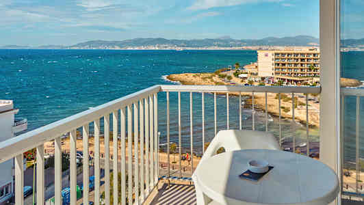 Näkymä parvekkeelta rannikolle, jossa meri ja rakennuksia taustalla. (Tekoälyn luoma teksti)