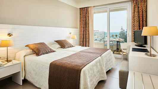 Hotellihuone, jossa kaksi erillistä sänkyä ja parveke. (Tekoälyn luoma teksti)