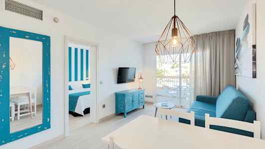 Olohuone, jossa sinisiä huonekaluja, roikkuva lamppu ja avoin parveke. (Tekoälyn luoma teksti)