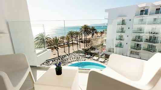 Näkymä parvekkeelta kohti uima-allasta, palmuja ja merta. (Tekoälyn luoma teksti)